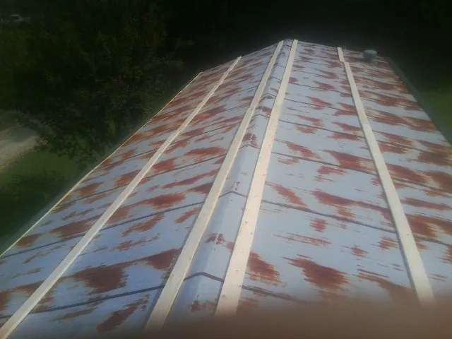 Rusted metal roof panels with new wood purlins before replacement — Storm Damage Roof Repair in Creswell by Roofing Brothers