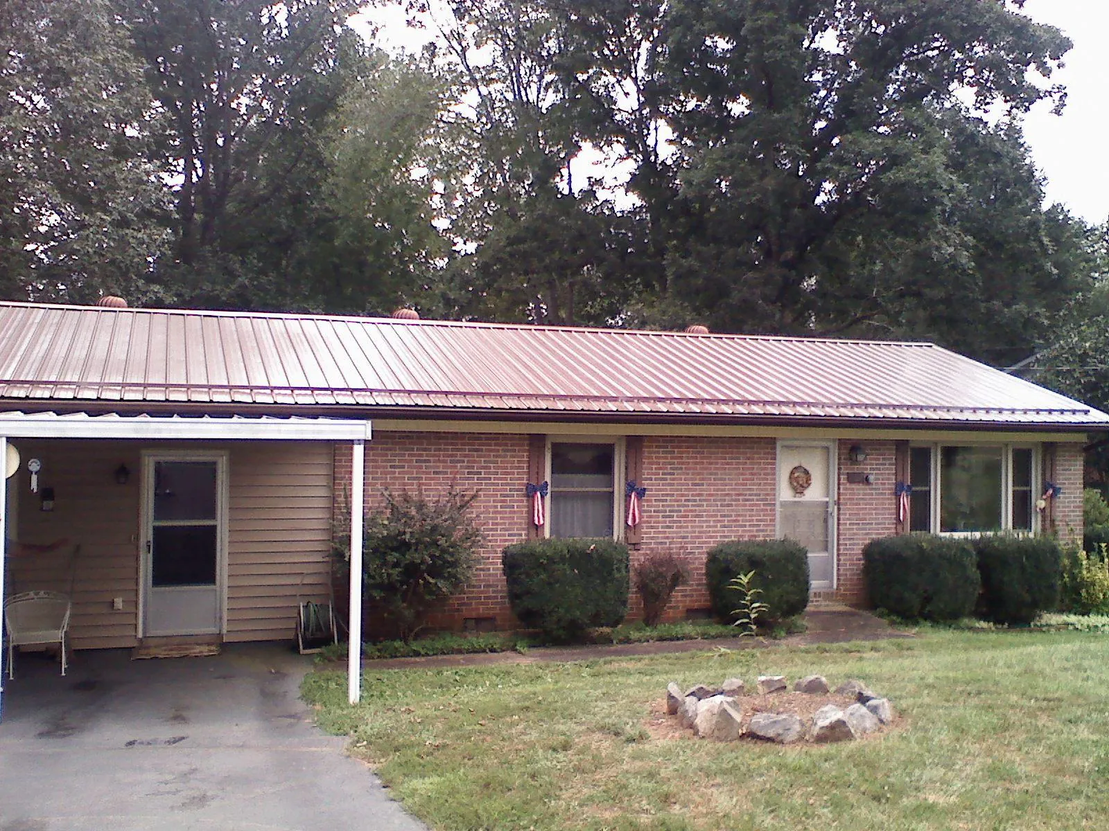 Bronze metal roof and carport on a brick ranch home — Roof Repair work by our crew in Creswell