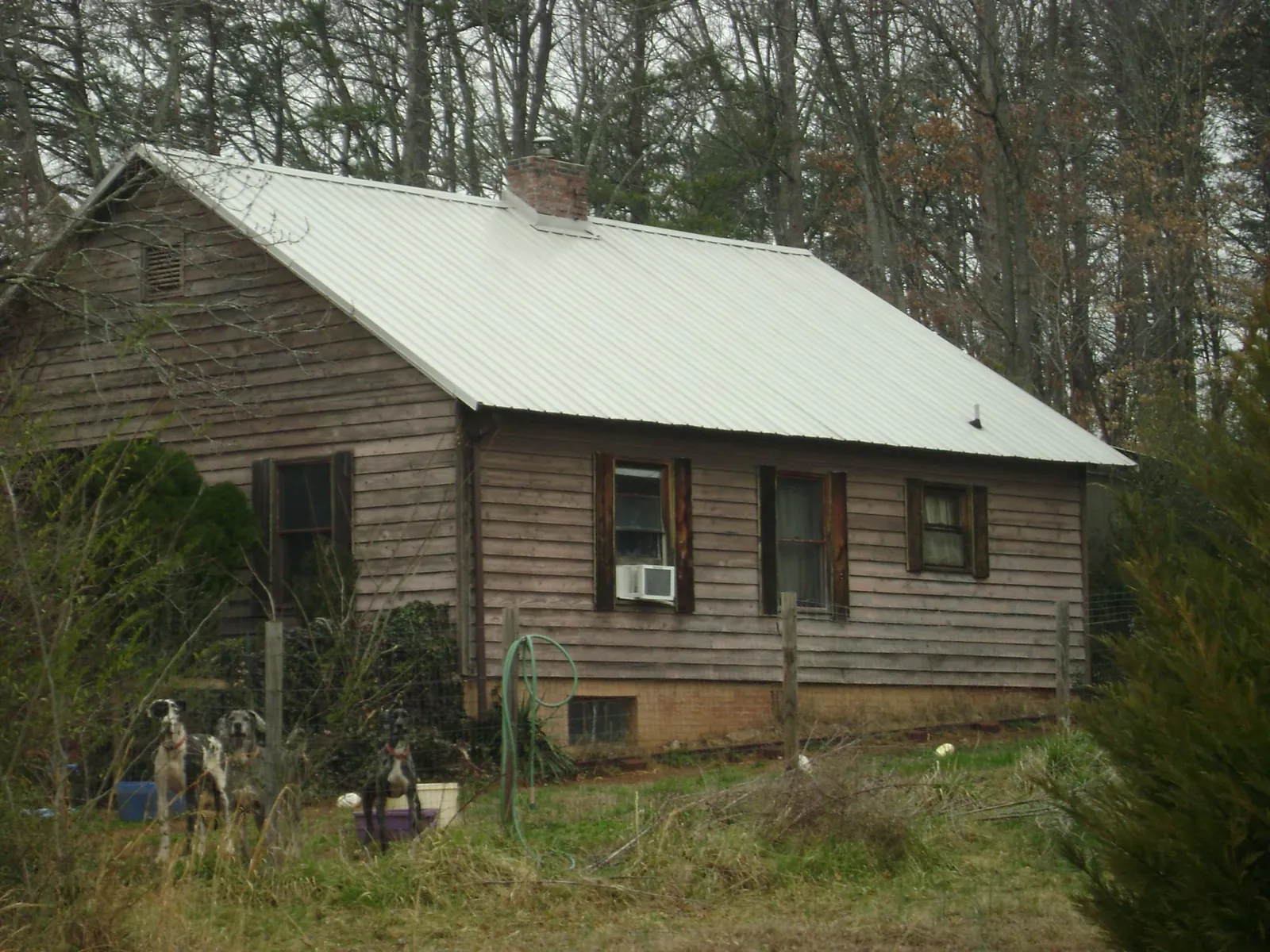 White metal roof on an old wood sided farmhouse, from a Metal Roof Installation job in Creswell
